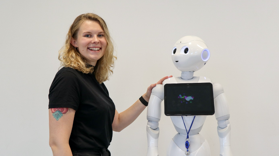 Åse Kleven på jobb som ansvarlig for Kongsberg Innovation Center, sammen med roboten Pepper. 